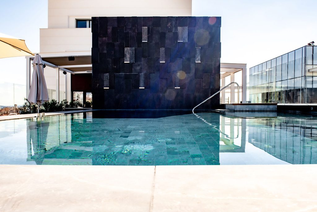 Terraza piscina del Hotel Hyatt Madrid con revestimiento arquitectónico realizado en piedra natural negra Gramablack®.